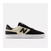 A New Balance low-top sneaker in black and cream suede, featuring a prominent black 'N' logo on the side, black laces, and a thick white platform sole, shown against a light gray background.