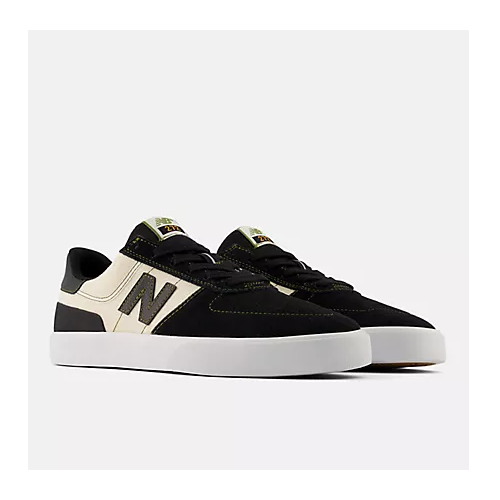 A pair of New Balance low-top skate shoes in black suede and cream canvas, featuring the signature 'N' logo on the side, black laces, and thick white platform soles, set against a plain light gray background.
