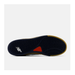 The bottom sole of a New Balance sneaker, showing a dark navy-blue tread with a white New Balance logo, a small red accent, and a gum-colored edge.