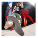A photo of Andy Anderson doing a skateboard trick in front of a glass skyscraper building and red sculpture behind him. 