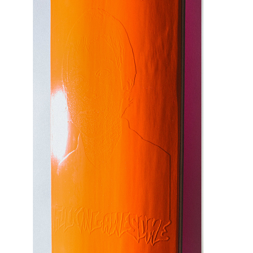 A close up picture of a bright orange FA skateboard deck with an embossed graphic and FA logo on a white background. 