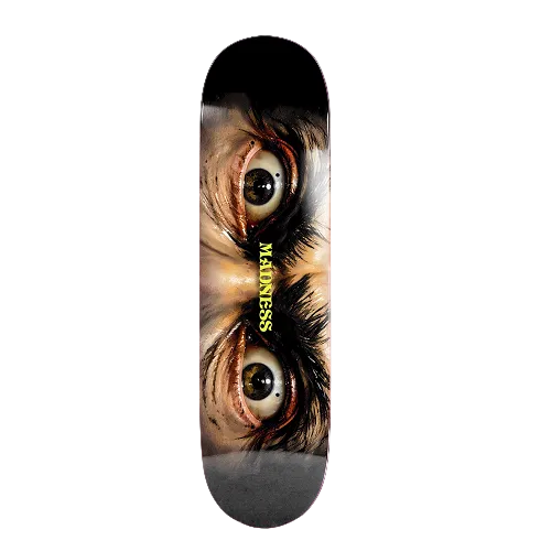 A skateboard deck featuring a graphic print of two wide-open eyes looking upward, with the word 'MADNESS' printed vertically in yellow near the center, shown against a black background.