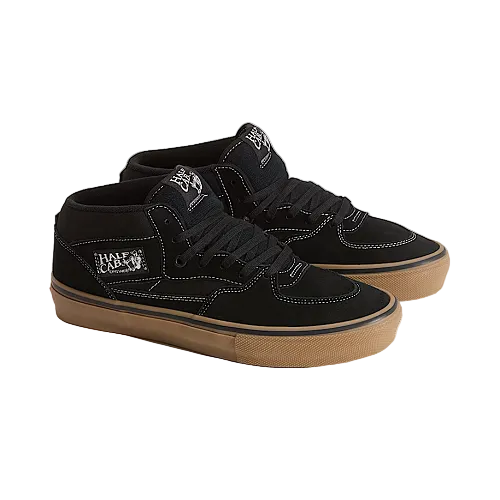 Black high-top sneakers with brown soles on a light beige background