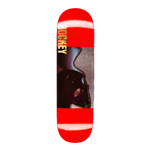 A red Hockey skateboard featuring a picture of black blob and the text Hockey on a white background. 