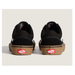 A pair of black Vans Old Skool sneakers shown from the back, featuring a brown gum sole and the signature red Vans logo on the heel.
