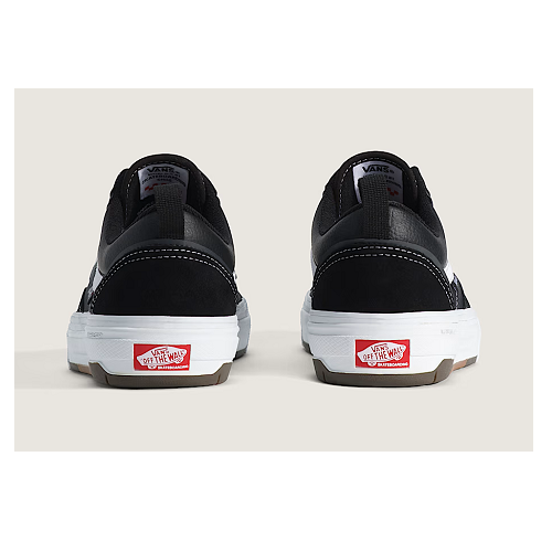A pair of Vans Old Skool Wafflecup sneakers shown from the back, featuring a black upper, white soles, and red Vans logo patches on the heel.