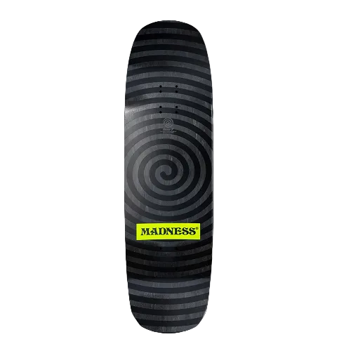 A skateboard deck featuring a black and gray spiral stripe pattern with a bright yellow 'MADNESS' logo label near the bottom, shown against a solid black background.