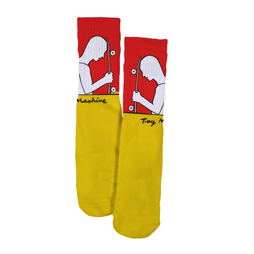 A pair of Toy Machine socks half orange and half yellow featuring a person holding a skateboard with the text Toy machine.