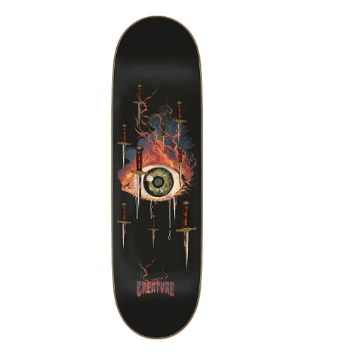 A black Creature skateboard featuring an eyeball with flames for eye lashes and several daggers floating around it with the word Creature. 